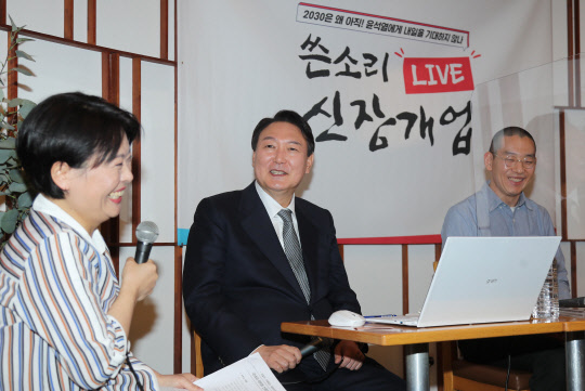 국민의힘 윤석열(가운데) 대선 후보가 14일 저녁 서울 여의도 한 카페에서 열린 후보 직속 '내일이 기대되는 대한민국 위원회'(내기대 위원회)의 토크쇼 '쓴소리 라이브 신장개업'에 참석해 윤희숙(왼쪽) 내기대 위원장의 발언을 듣고 있다. <연합뉴스>
